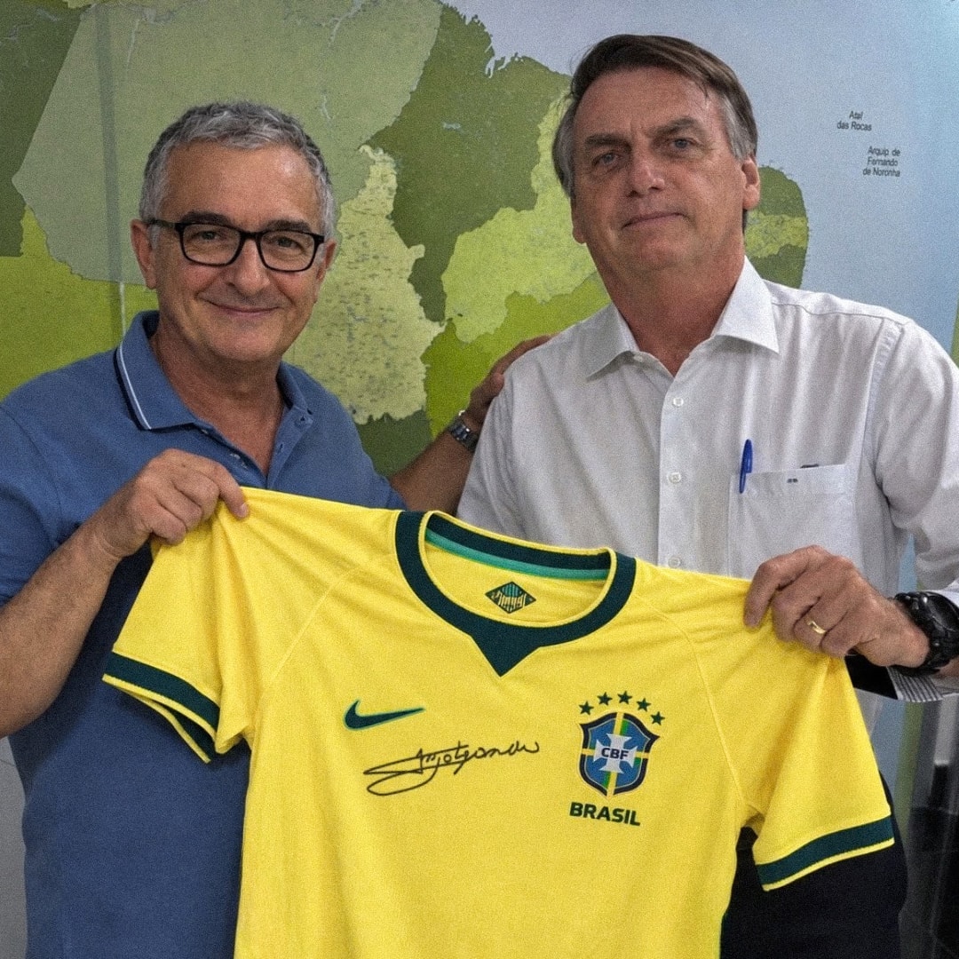Fotografia de contexto: duas pessoas segurando a camisa autografada